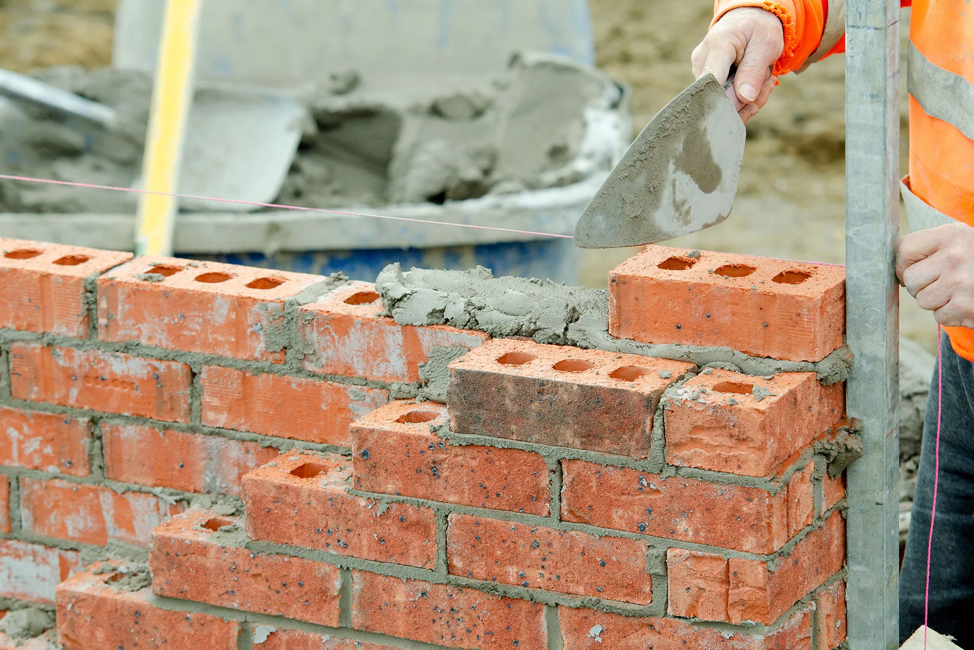 A brick wall being built with a trowel.