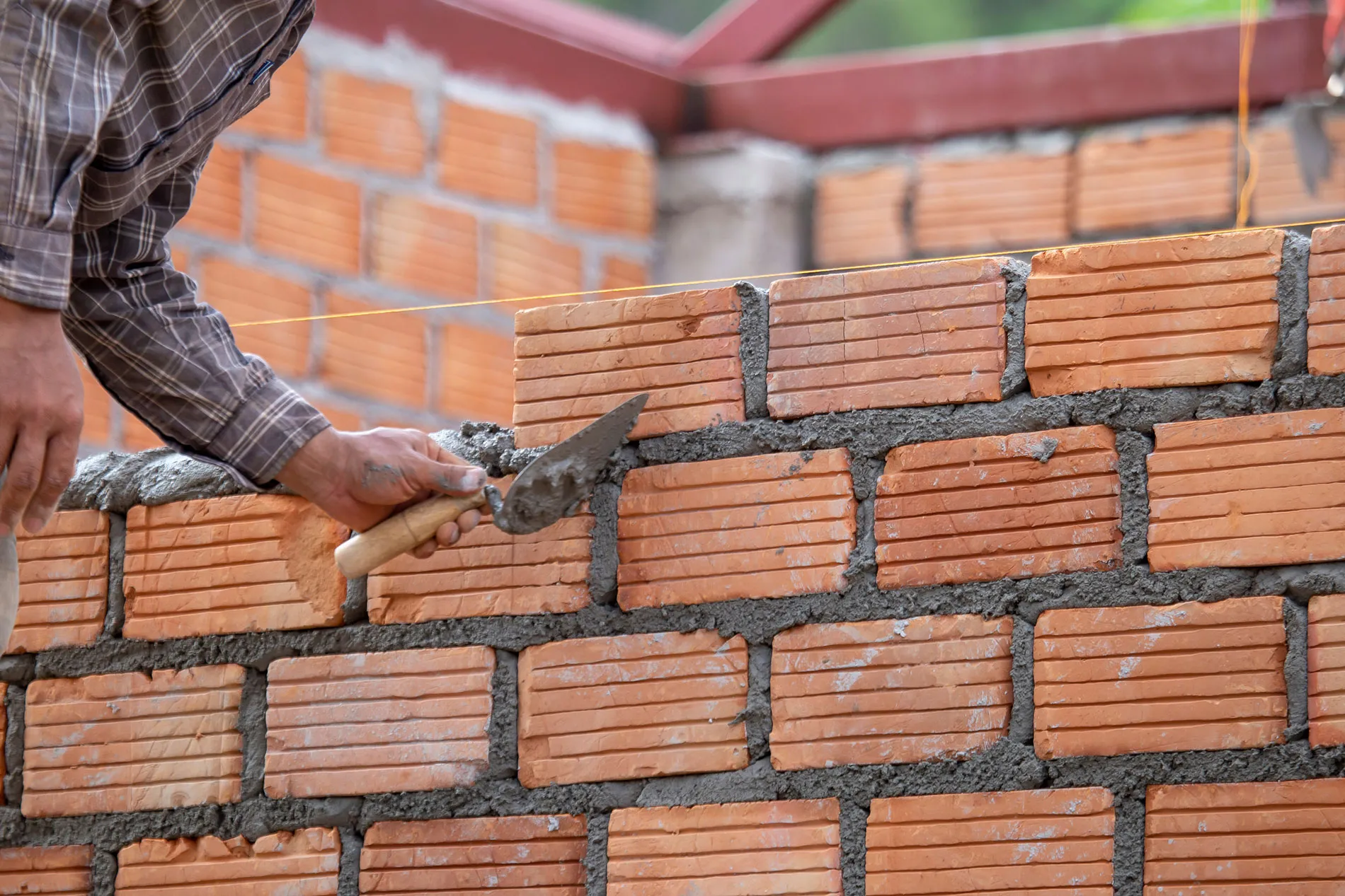 A man is working on a brick wall.